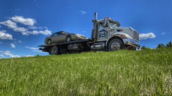 Flatbed towing truck transporting a vehicle