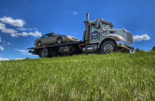 Flatbed tow truck transporting a vehicle